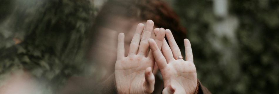 person in brown long sleeve shirt covering face with hand