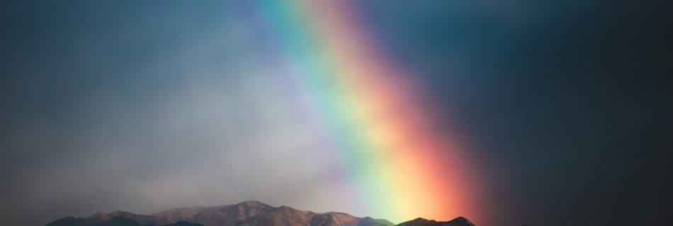 mountain range under rainbow during night time