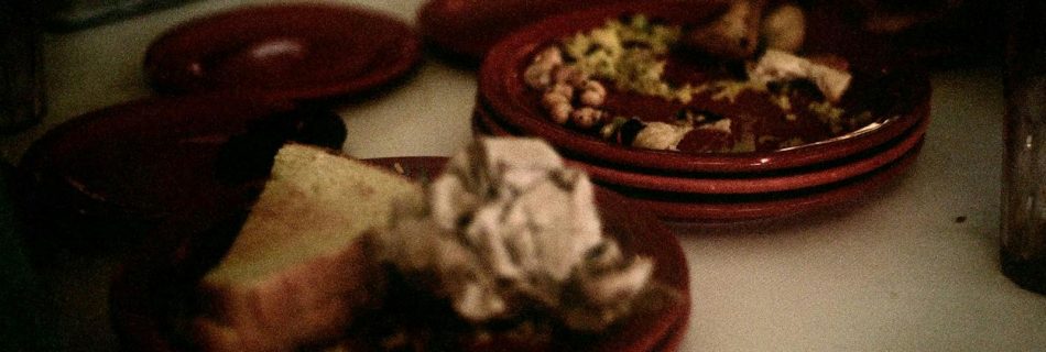 A table topped with red plates filled with food
