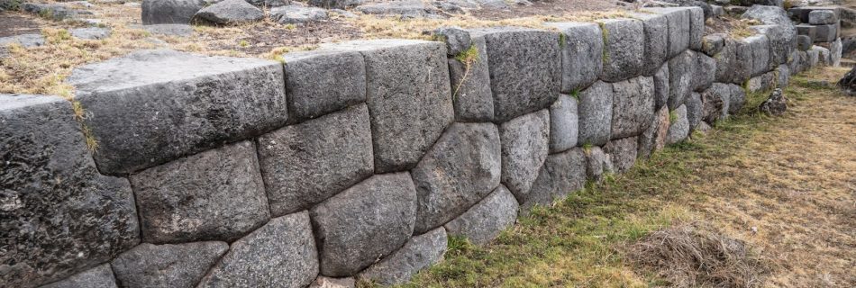 a stone wall in the middle of a field